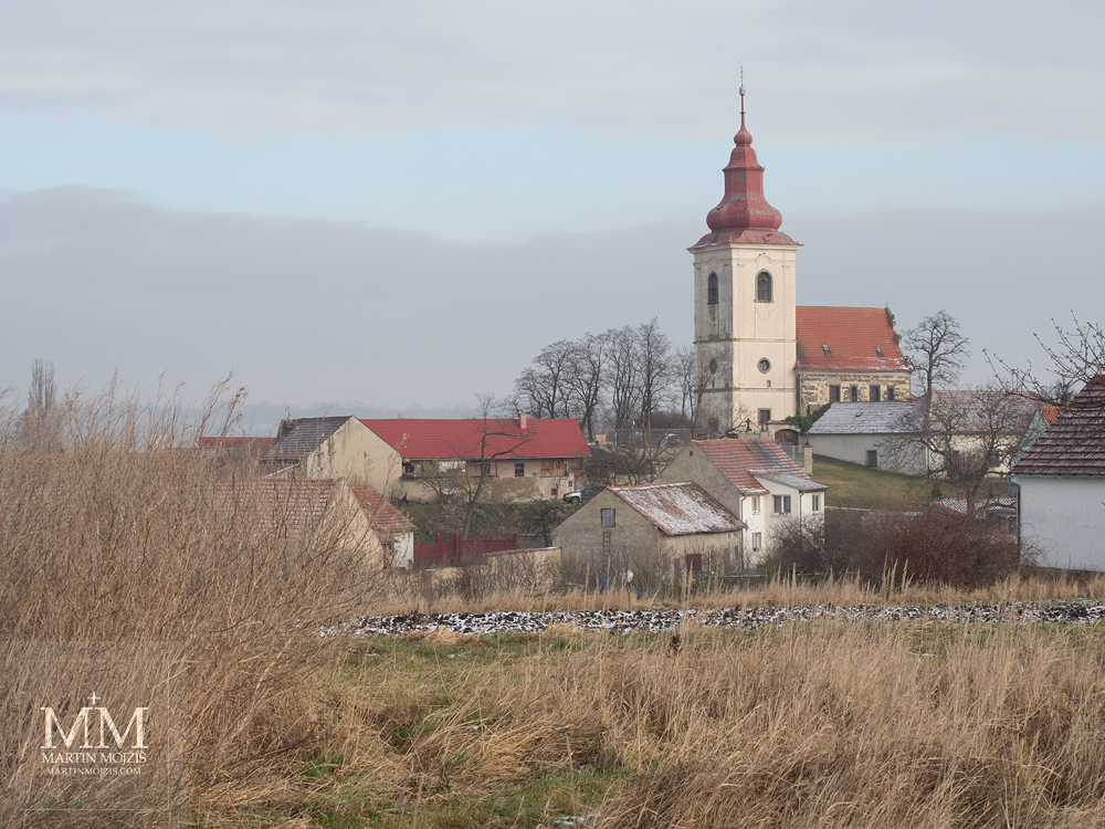 Barokní kostel ve vesnici. Fotografie vytvořena objektivem Olympus 12 - 40 mm 2.8 Pro.